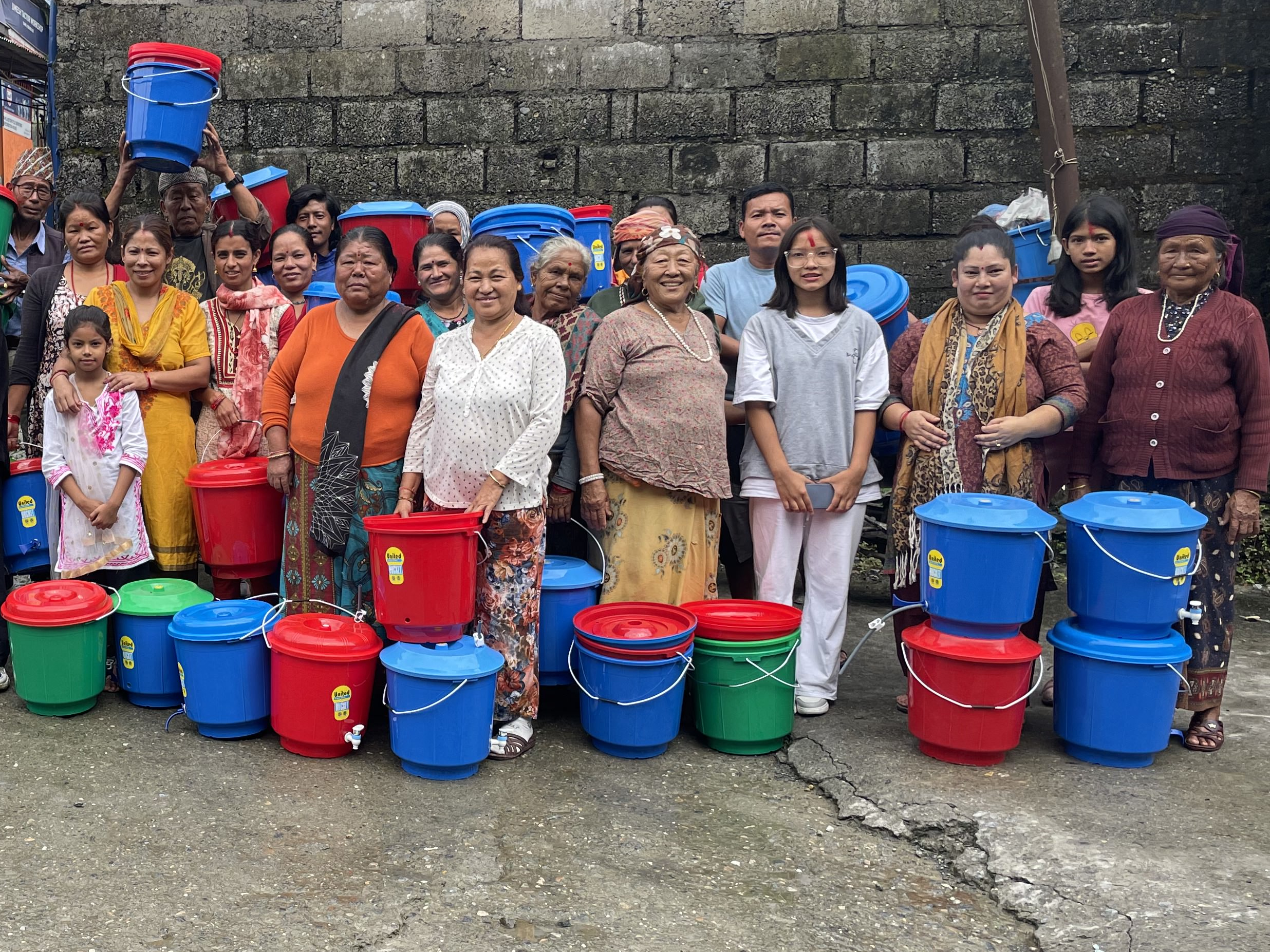 Community members gathered with newly distributed household water filters and buckets