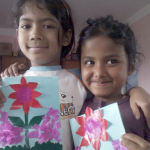 Two young House Daughters holding handmade flower artwork