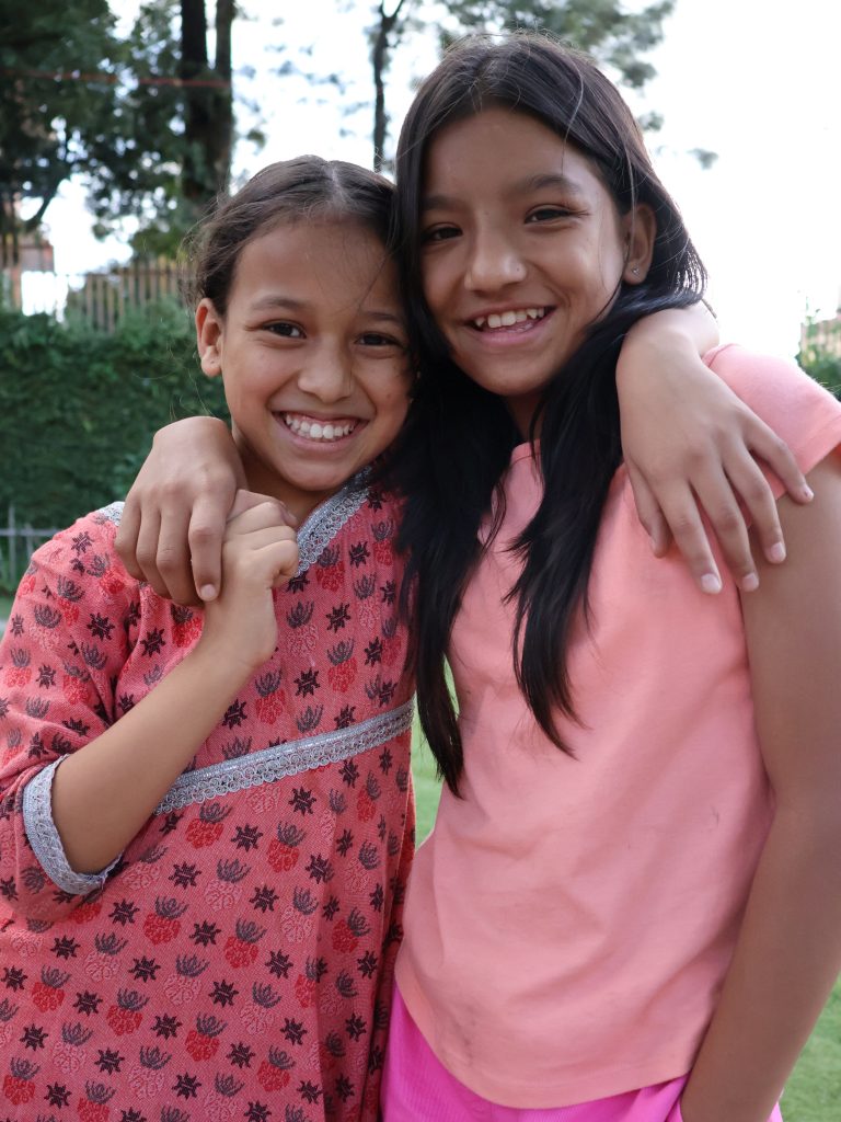 House Daughters Rejina and Tara smiling together at home