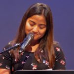 House Daughter Manu speaking at a memorial event in New York City